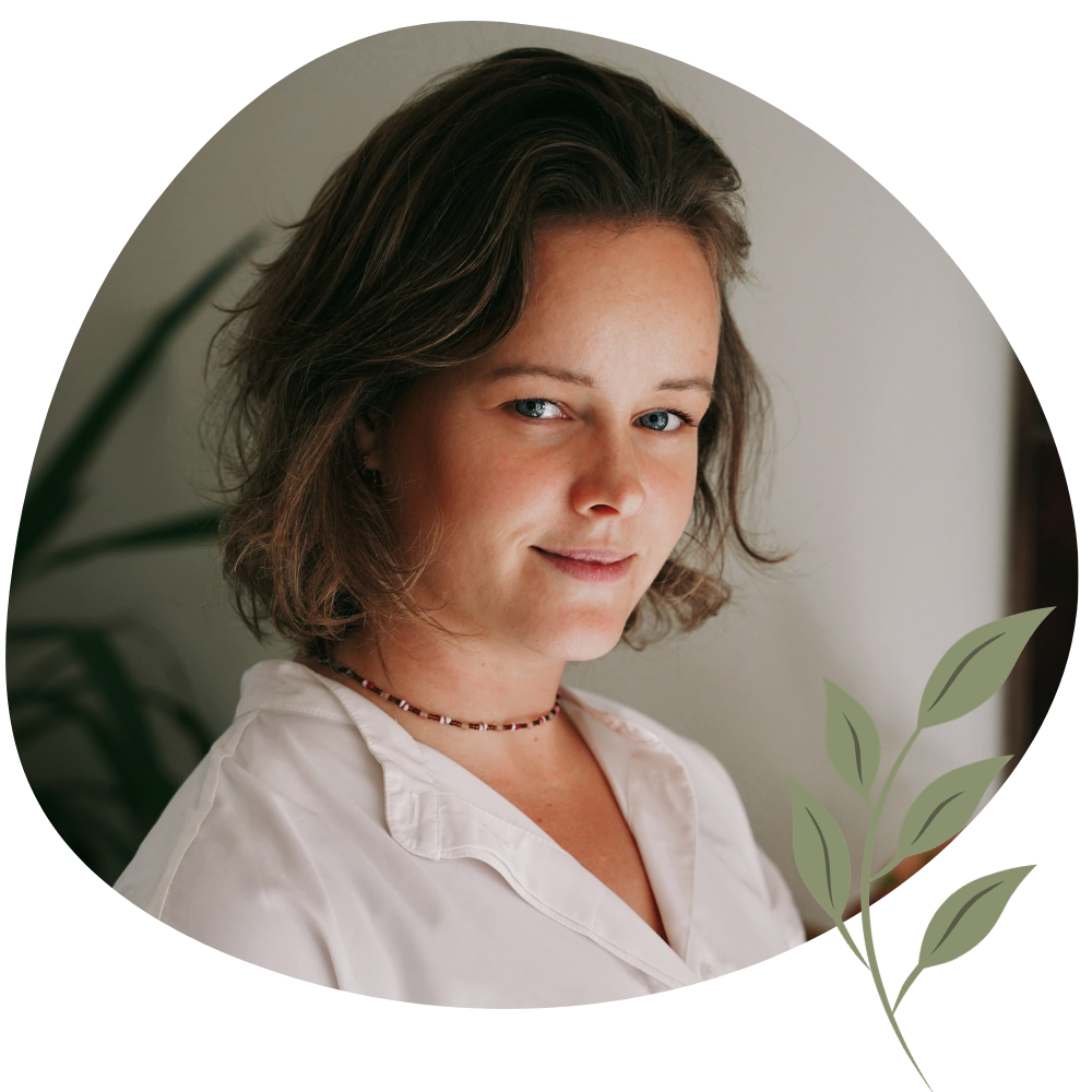 Portret van vrouw met een donkere wavy bob die in de camera kijkt. de afbeelding is rond en rechts onderin staat een decoratief groen takje.